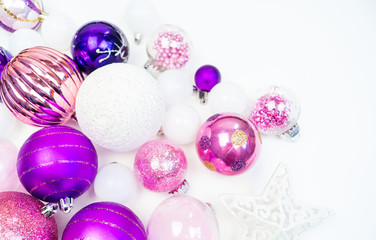 Gentle pink and purple baubles on a white background. Christmas mood.