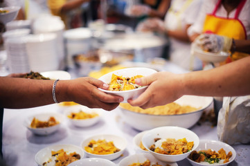 Hand offered to donate food from a rich man Share : Feeding Concepts