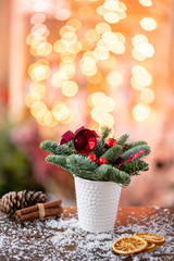 Christmas arrangement with Norwegian pine Nobilis and decorated with Christmas decor in a coffee Cup. Garland bokeh on background. Christmas love. Dark wooden table sprinkled with snow