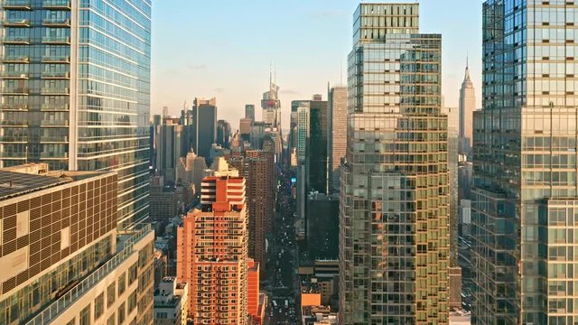 Aerial drone footage of New York skyline along 42nd street canyon, with pull back camera motion