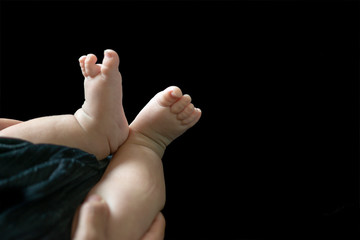 Fototapeta premium Baby feet in mother hands. Mom and her Child. Happy Family concept. Beautiful conceptual image of Maternity