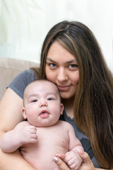 Mother is holding her newborn infant son