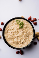Healthy Peanut chutney made using Groundnut / Shengdana or mungfali. served in a small bowl with raw whole. Selective focus