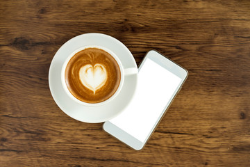 Smart phone with latte art coffee on wooden background