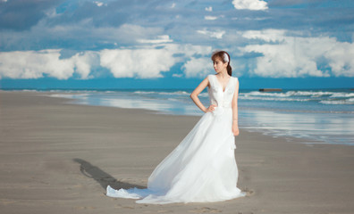Fototapeta na wymiar bride in white dress on the beach