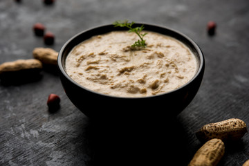 Healthy Peanut chutney made using Groundnut / Shengdana or mungfali. served in a small bowl with raw whole. Selective focus