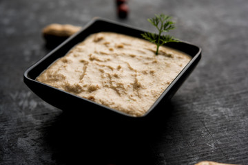 Healthy Peanut chutney made using Groundnut / Shengdana or mungfali. served in a small bowl with raw whole. Selective focus
