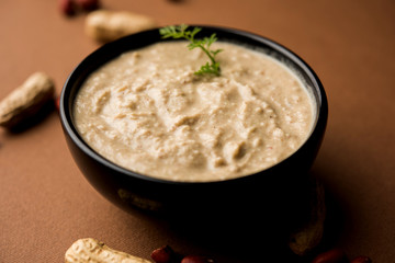 Healthy Peanut chutney made using Groundnut / Shengdana or mungfali. served in a small bowl with raw whole. Selective focus
