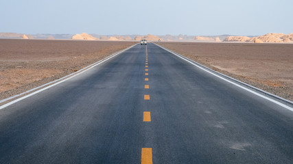 Car traveling on road in gobi desert in Dunhuang Yardang National Geopark, Gansu, China