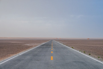 Empty two-lane road in gobi desert in Dunhuang Yardang National Geopark, Gansu, China
