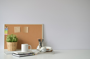 Copy space office desk with coffee mug, notebook and office supply with selective focus.