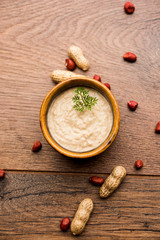 Healthy Peanut chutney made using Groundnut / Shengdana or mungfali. served in a small bowl with raw whole. Selective focus