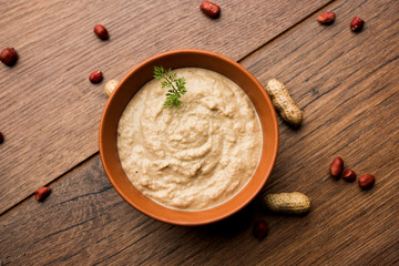 Healthy Peanut chutney made using Groundnut / Shengdana or mungfali. served in a small bowl with raw whole. Selective focus