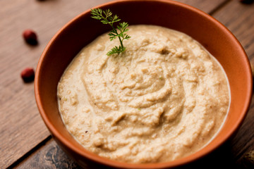 Healthy Peanut chutney made using Groundnut / Shengdana or mungfali. served in a small bowl with raw whole. Selective focus