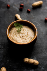 Healthy Peanut chutney made using Groundnut / Shengdana or mungfali. served in a small bowl with raw whole. Selective focus