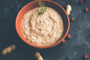 Healthy Peanut chutney made using Groundnut / Shengdana or mungfali. served in a small bowl with raw whole. Selective focus
