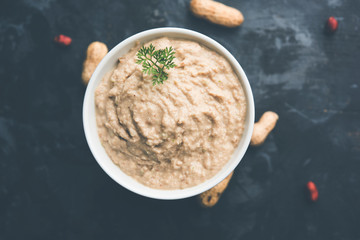 Healthy Peanut chutney made using Groundnut / Shengdana or mungfali. served in a small bowl with raw whole. Selective focus