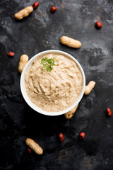 Healthy Peanut chutney made using Groundnut / Shengdana or mungfali. served in a small bowl with raw whole. Selective focus