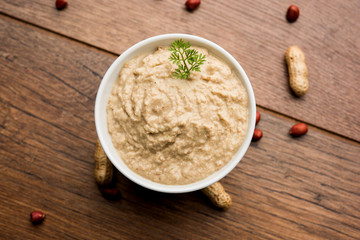 Healthy Peanut chutney made using Groundnut / Shengdana or mungfali. served in a small bowl with raw whole. Selective focus