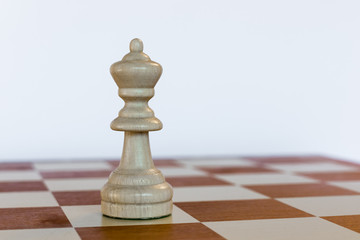 White queen on white square on chessboard