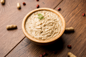 Healthy Peanut chutney made using Groundnut / Shengdana or mungfali. served in a small bowl with raw whole. Selective focus