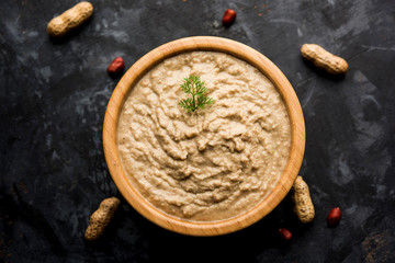 Healthy Peanut chutney made using Groundnut / Shengdana or mungfali. served in a small bowl with raw whole. Selective focus