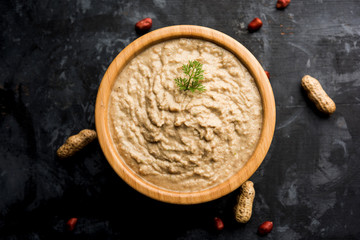 Healthy Peanut chutney made using Groundnut / Shengdana or mungfali. served in a small bowl with raw whole. Selective focus