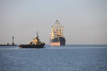 Naklejka premium Dry cargo ship approaching the seaport berth