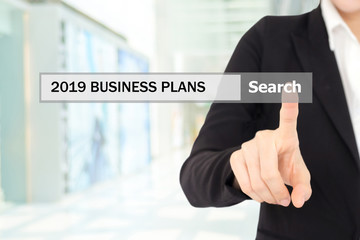 Businesswoman hand touching 2019 business plans on search bar over blur office background, success in business concept
