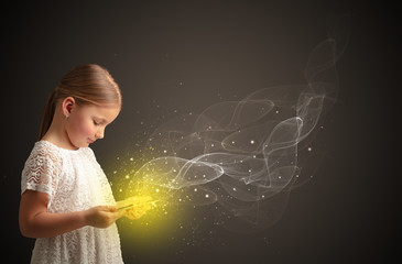 Little cute girl playing on sparkling tablet
