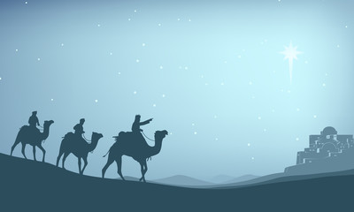 Christian Christmas Nativity Scene of baby Jesus in the manger with Mary and Joseph in silhouette surrounded by animals and the three wise men magi with the city of Bethlehem in the distance