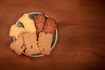 An overhead photo of an assortment of traditional Christmas Spekulatius cookies, shot from the top on a dark rustic background with copy space