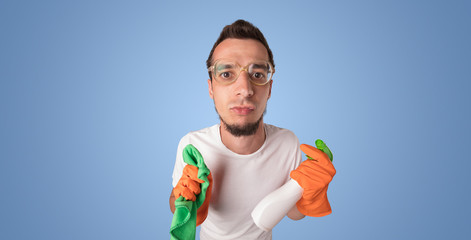 Housekeeper with cleaning product and equipment in front of a blue empty wall
