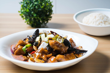 kung pao chicken is a spicy, stir-fried Chinese dish made with chicken, peanuts, vegetables, and dried chili peppers