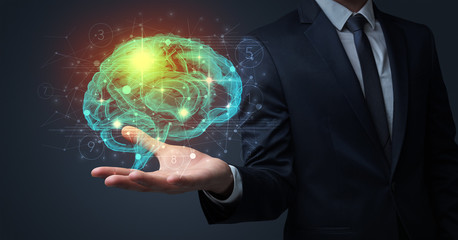 Businessman holding human brain on his hand with logistics symbols around