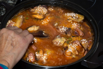 cooking tasty rice with seafood- paella a la marinera