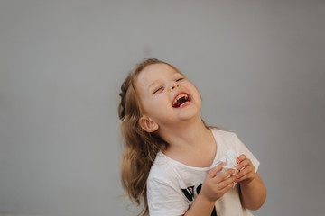 Beautiful little girl smile to camera. Gray background. we are all kids