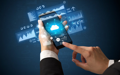 Female hand using smartphone with financial tracking concept illustrated by graphs and symbols