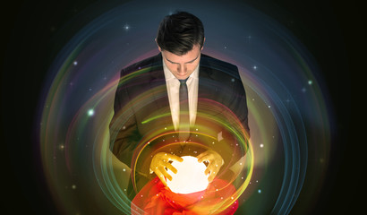 Young handsome man looking to the future of the universe in a crystal ball
