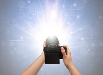 Naked hand taking picture with digital camera and glowing flash concept

