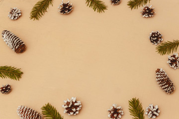 Wood christmas background with fir branches, fir and pine cones, top view, copyspace.