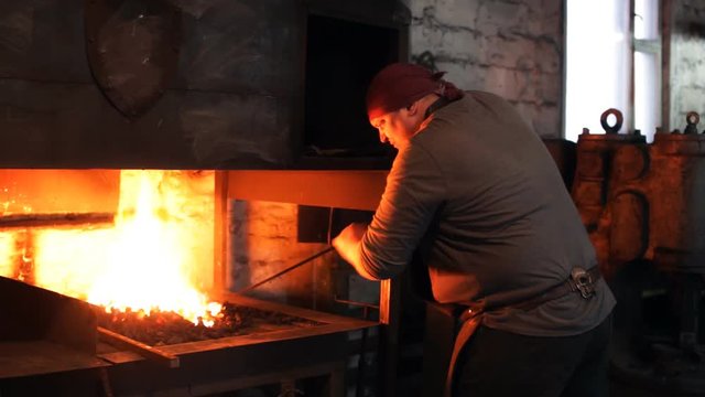 Blacksmith warms the stove