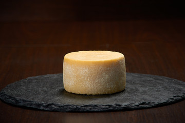 Old weathered cheese on a stone plate