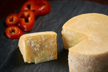 Old aged cheese and red pepper on a stone plate