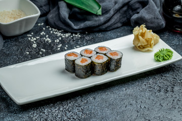 salmon roll maki on black background