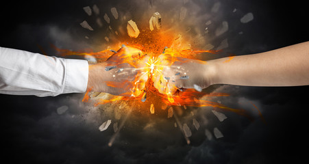 Two hands fighting and breaking a rock into small pieces
