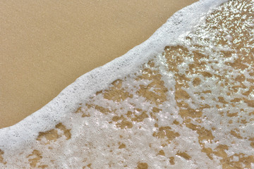 Sea foam on golden sand