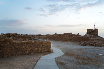 The tallest tower of Masada against the cloudy sky at dawn in the sun. Historical excavations on...