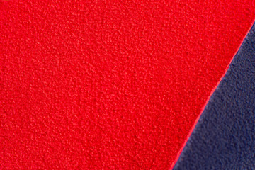 Fototapeta premium Texture of fleece fabric. Red and blue fleece fabric creates a textural background. Fabric fleece for sewing and design of fashionable clothes and objects.