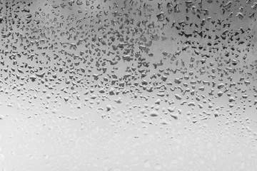 Natural water drops on glass in black and white background